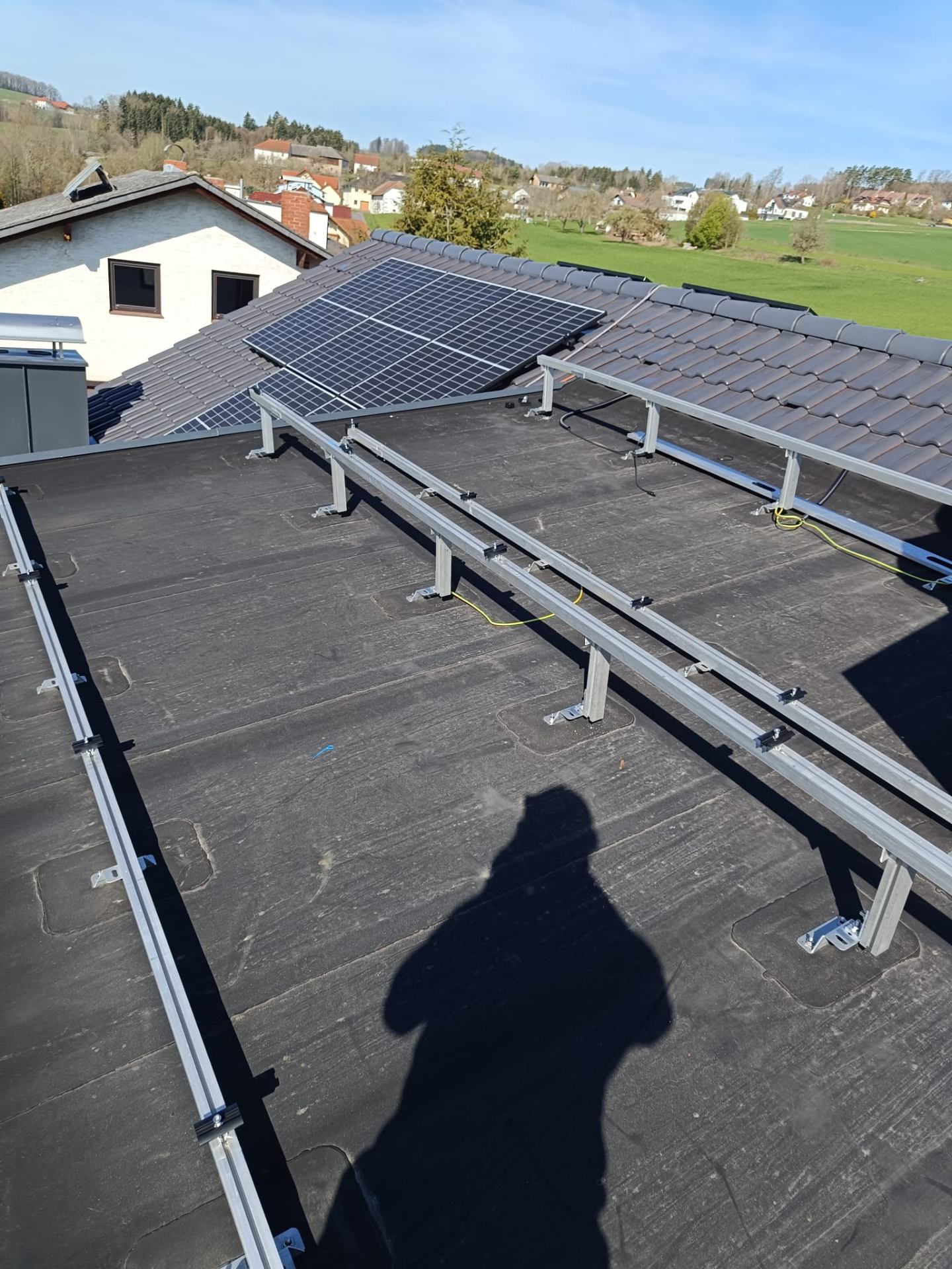 Aluminium-Unterkonstruktion für eine Photovoltaik-Anlage auf einem Flachdach mit Dorfblick